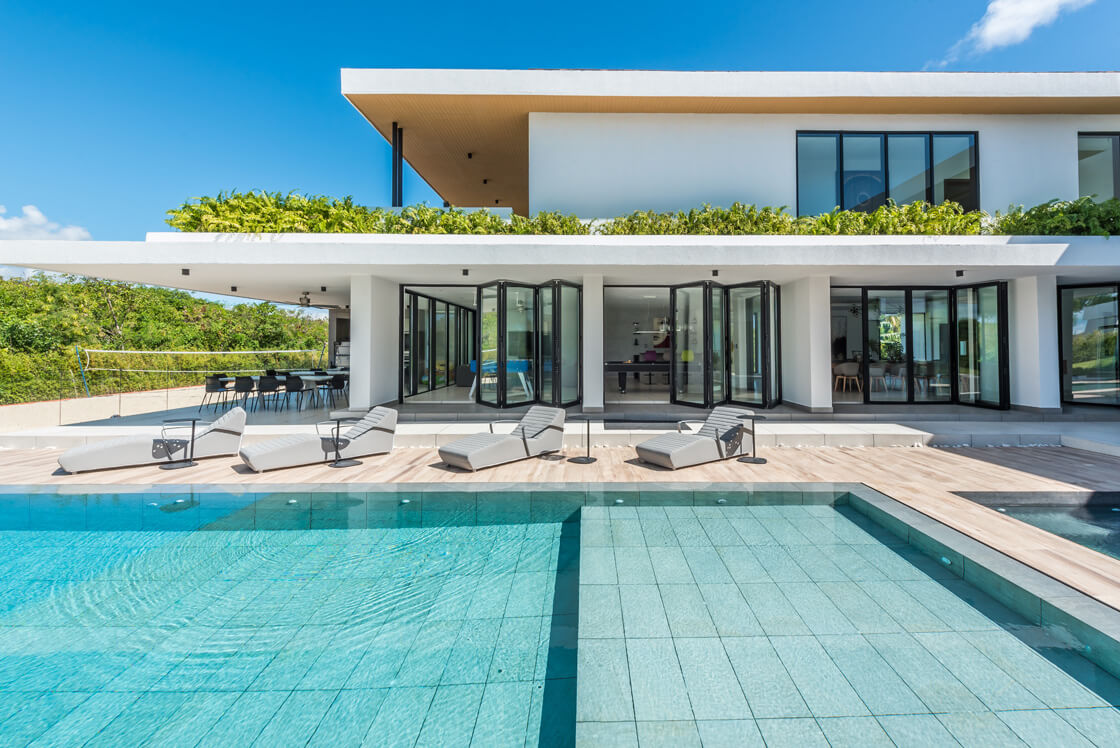 shot looking over a swimming pool, showing cortizo bi-fold doors on the holiday home